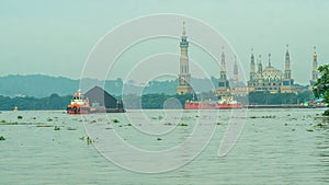 Tugboat drag barge full of coal crossing Mahakam River, Samarinda, in the morning.