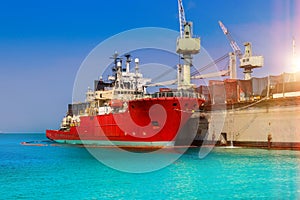 Tugboat moored alongside hear floating dock in the blue sea