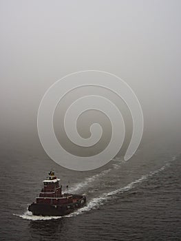 Tugboat Motoring Through Foggy Sea