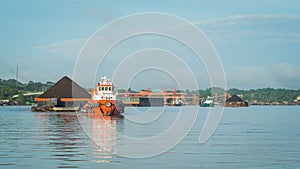 Tugboat pull heavy loaded barge of coal