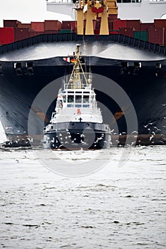 Tugboat pulling freighter photo