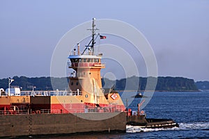 Tugboat pushing barge photo