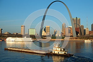 Tugboat pushing barge in front of Archway in St. Louis, Missouri