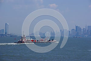 Tugboat pushing barge in New York Harbor,