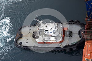 Tugboat pushing on a containership