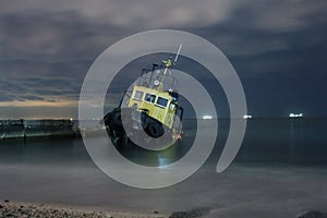 Tugboat ran aground, starry night sky with clouds.