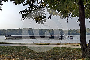 Tugboat with ship pass along the riverside park in Ruse town