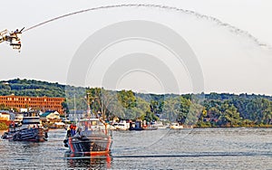 Tugboats arriving harbor event under water spray arc