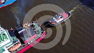 Tugboats assisting cargo ship sea in the morning.