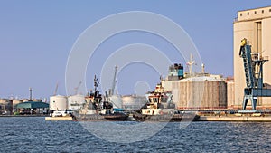 Tugs moored at an oil refinery on a sunny, Port of Antwerp, Belgium.