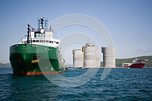 Tugs towing base offshore oil platform