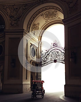 Tuk tuk driving through the huge building arch