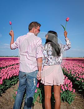 Tulip fields in the Netherlands, couple men and woman in flower field during Spring in the Nethertlands