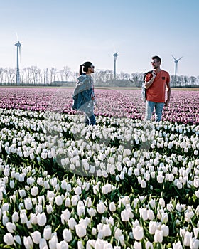 Tulip flower field during sunset dusk in the Netherlands Noordoostpolder Europe, happy young couple men and woman with