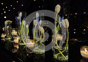 Tulip flowers decoration with candles at night, indoor luxury wedding with low light romantic ambient