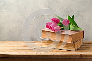 Tulip flowers and vintage books on wooden table