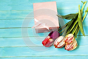Tulips with box on a wooden background