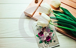 Tulips and card on wooden background and tray. In spring