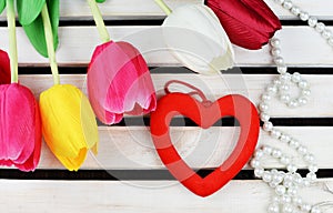 Tulips flowers with heart decor for Valentine`s Day holiday March 8 Mother`s Day on wooden background