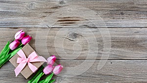 Tulips and gift for Mothers day on rustic wooden background
