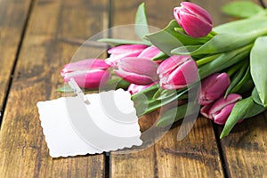Tulips on old brown wooden table with a Stickies