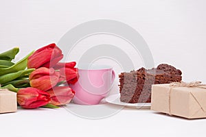 Tulips, presents, cake, cup for mother, wife, daughter, girl. Happy birthday, Mother`s day. Woman`s day. Copy spase