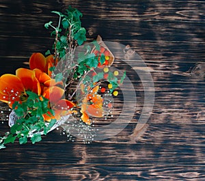 Tulips with sweets in a waffle horn on a wooden background