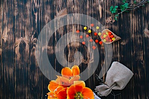 Tulips with sweets in a waffle horn on a wooden background