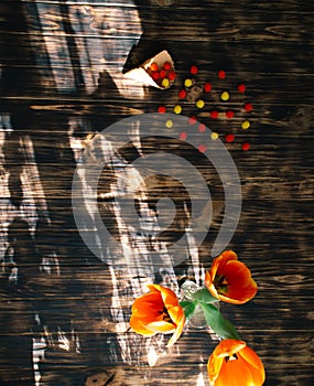 Tulips with sweets in a waffle horn on a wooden background