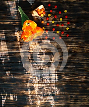 Tulips with sweets in a waffle horn on a wooden background