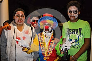 Tulsa USA Four African American boyss in zombie face paint and one dressed like a clown givng two peace signs trick or treat on Ha