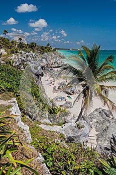 TULUM, MEXIO - FEB 29, 2016: Tourists at the beach under the ruins of the ancient Maya city Tulum, Mexi