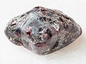 tumbled Almandine garnet crystals on white marble