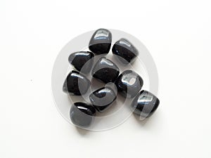 Tumbled Black Obsidian stones close up from top for crystal therapy treatments and reiki photo
