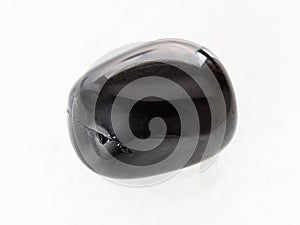 tumbled black Onyx gemstone on white marble