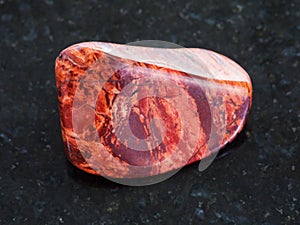 tumbled Brecciated red jasper gemstone on dark