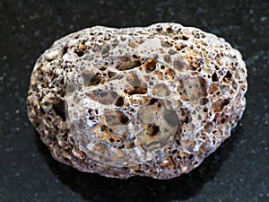 Tumbled brown pumice stone on dark background