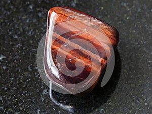 tumbled Bull's Eye gemstone on dark background