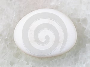 tumbled cacholong (white opal) gemstone on white photo
