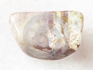 tumbled Cancrinite gemstone on white