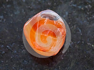 tumbled carnelian gem stone on dark background