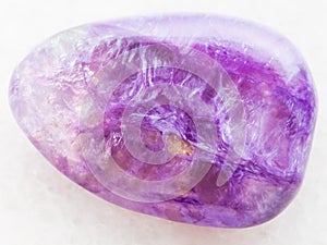 tumbled Charoite gemstone on white marble