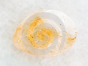 tumbled Citrine gem stone on white marble