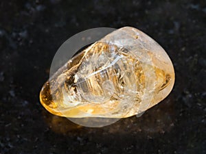 tumbled Citrine gemstone on dark background