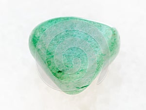 tumbled green Aventurine gem on white marble