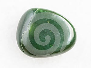 tumbled green nephrite gemstone on white marble photo