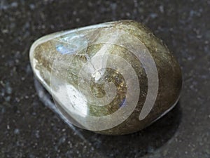 tumbled labradorite gem stone on dark background