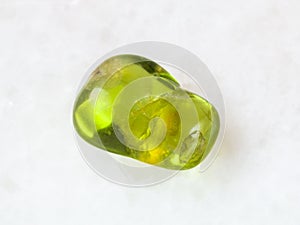 tumbled olivine gem stone on white