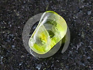 tumbled Peridot gem stone on dark background