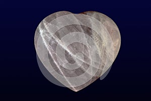 Tumbled and polished rose quartz heart on dark background